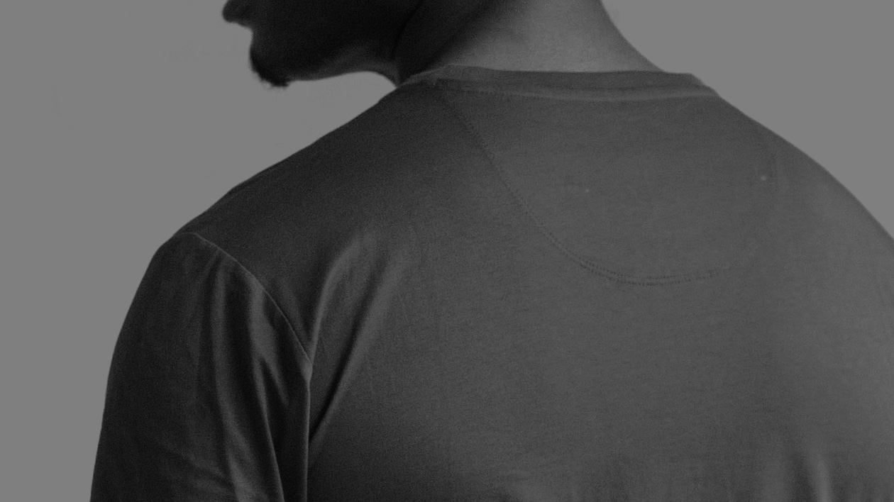 Black and white shoulder view photo of a man wearing a Filium-activated t-shirt